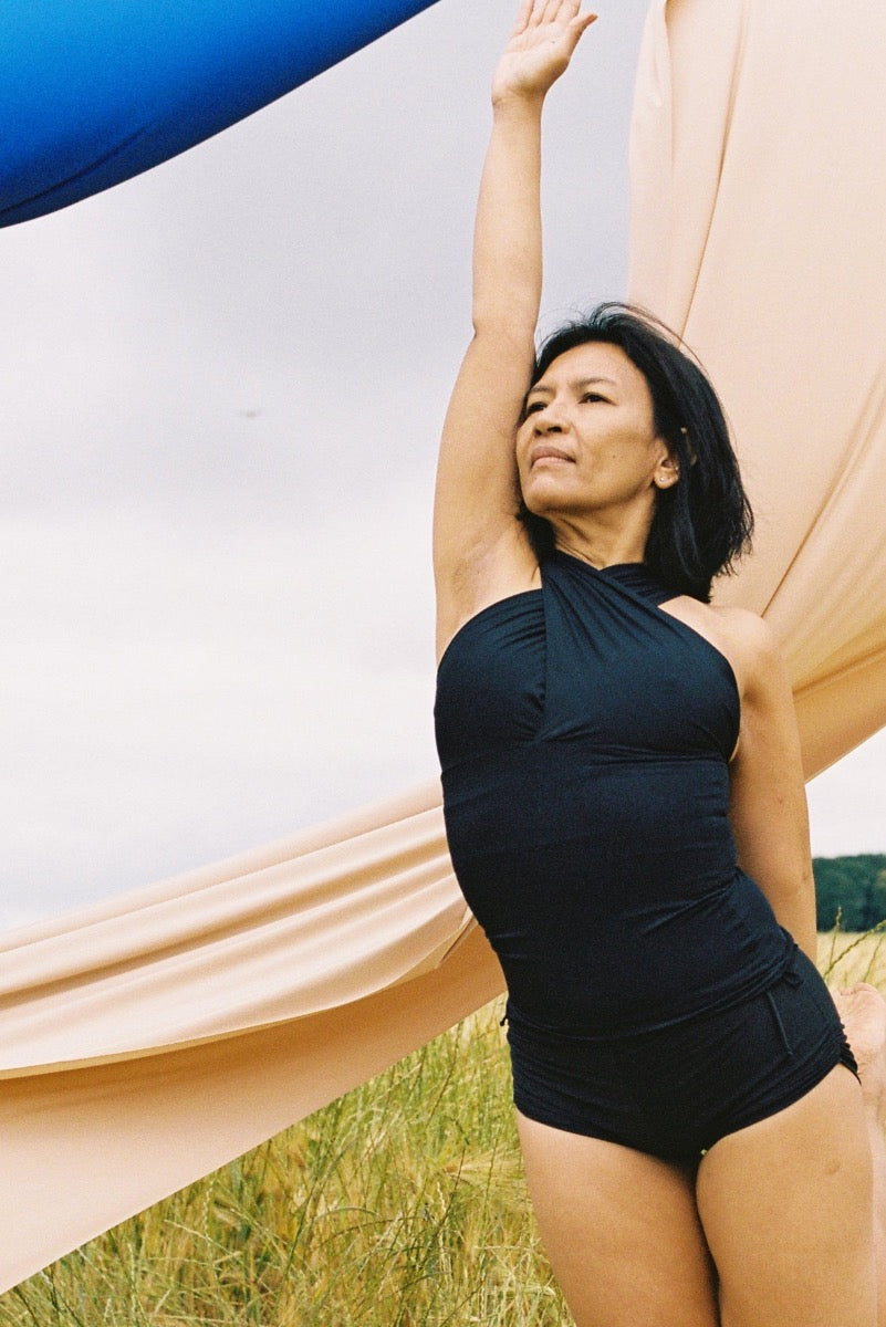 Woman wearing a yoga wear top the Draped top while doing a yoga pose in nature